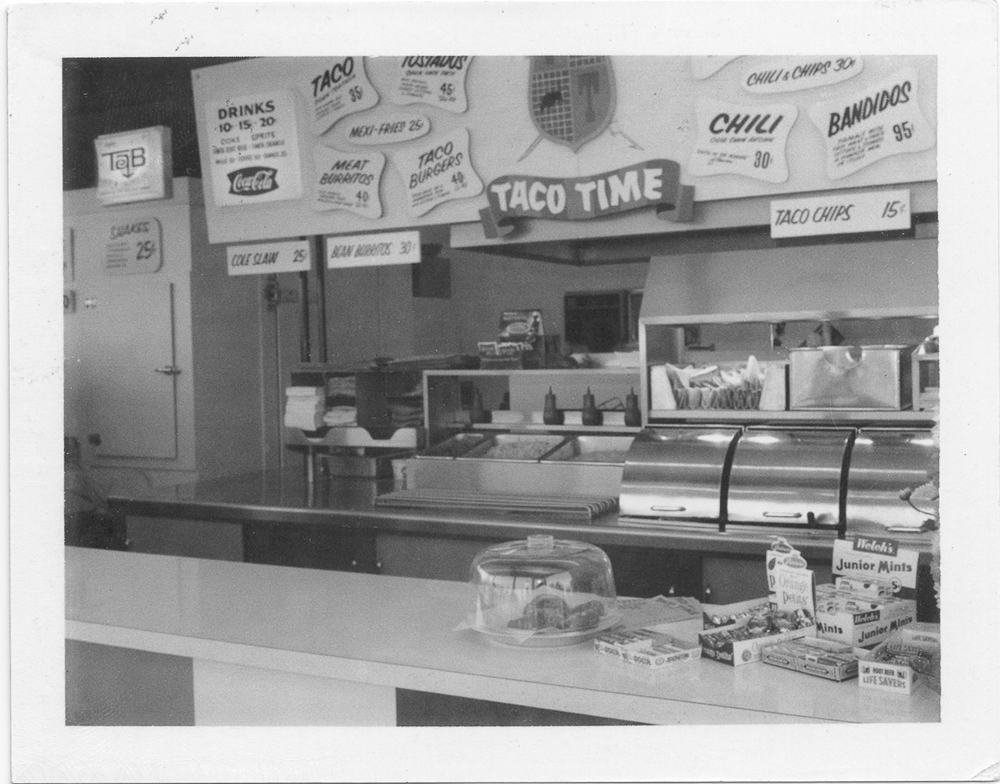 Vintage TacoTime Taco location in black and white with signs and churros on the counter in a glass case / Mexican restaurant franchise