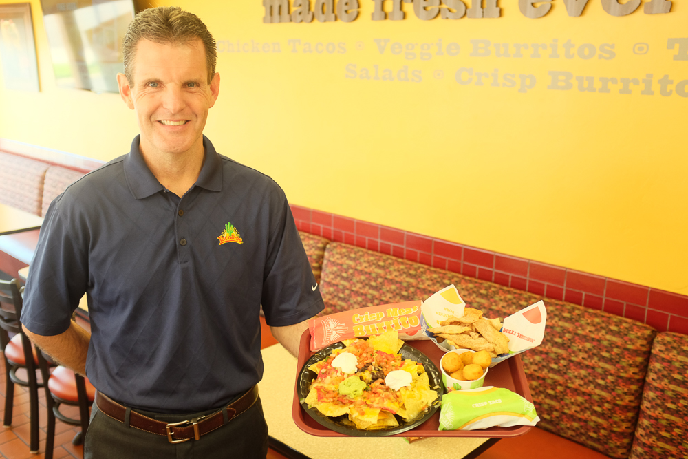 Owner of TacoTime holding a tray of food