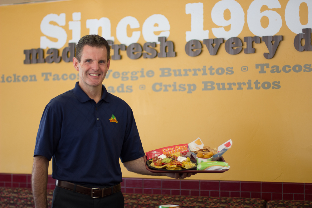 Kevin Gingrich smiling and holding a plate of TacoTime tacos