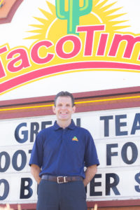 tacotime franchise president kevin gingrich in front of a TacoTime sign